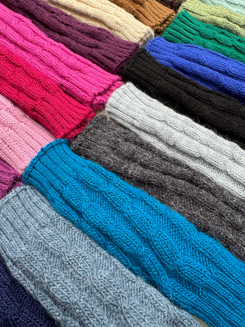 Cable-knit alpaca fingerless gloves fanned out in a range of colours