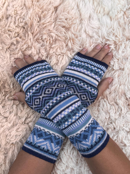 Navy & Powder Blue Fair Isle Baby Alpaca Fingerless Gloves worn on hands resting on a sheepskin rug